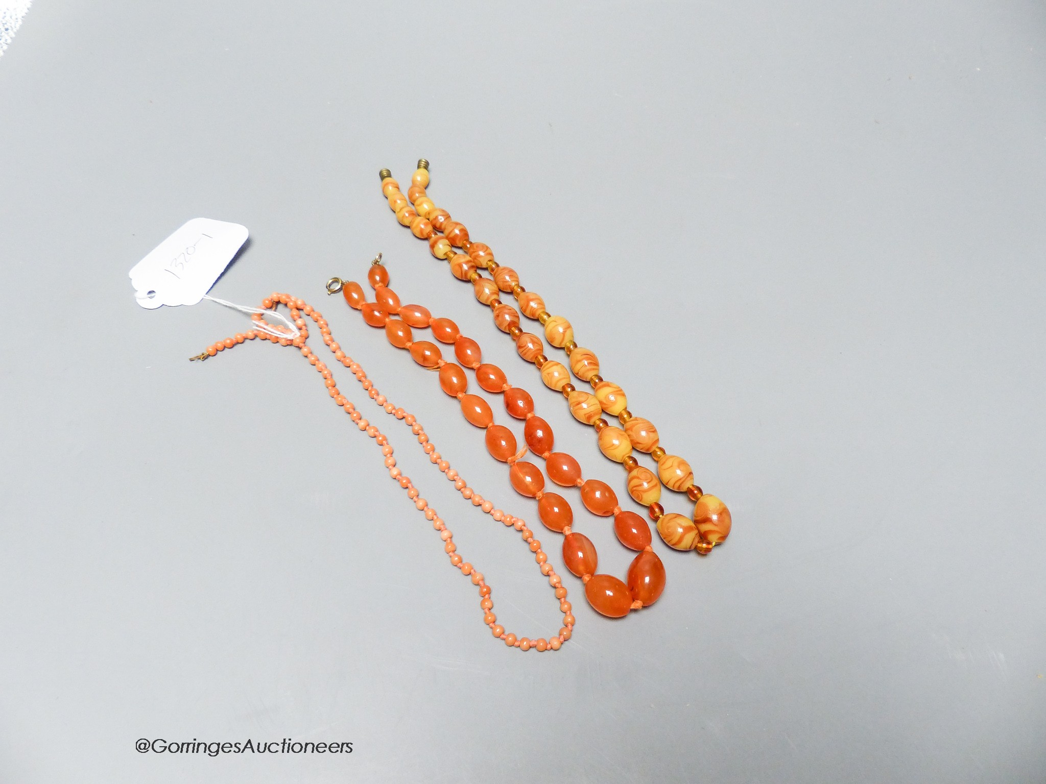 A coral bead necklace, 47cm and two other necklaces.